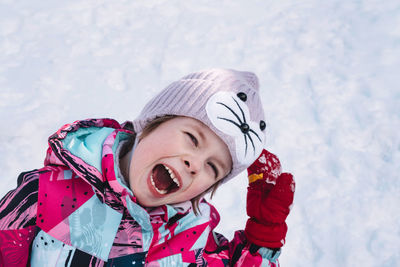 Happy and cheerful child outdoors in winter on the background of snow. hello winter