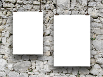 Close-up of paper hanging on stone wall