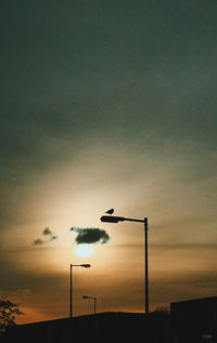 Low angle view of street light against sky at sunset