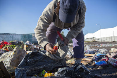 Man collecting garbage on field