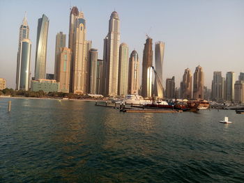 Panoramic view of sea and cityscape against clear sky