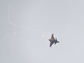 Low angle view of fighter plane flying against clear sky