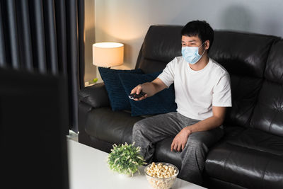 Rear view of man sitting on sofa at home