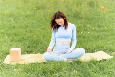 Woman sitting on grass in field
