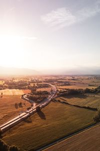 High angle view of country road amidst farms against sky