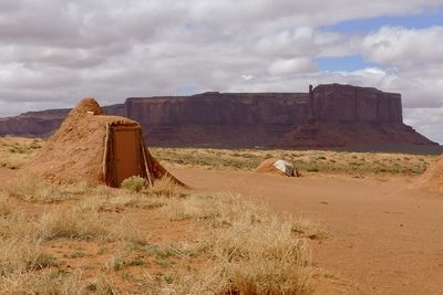 Scenic view of navajo hut in desert against sky