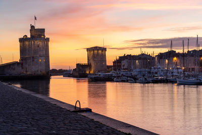 View of buildings at waterfront during sunset