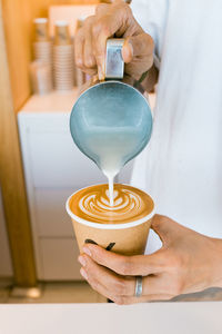 Midsection of woman pouring tea cup