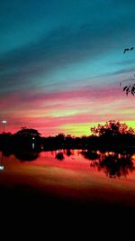 Scenic view of silhouette trees against romantic sky at sunset