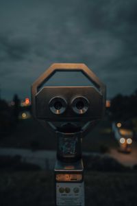 Close-up of coin-operated binoculars against sky during sunset