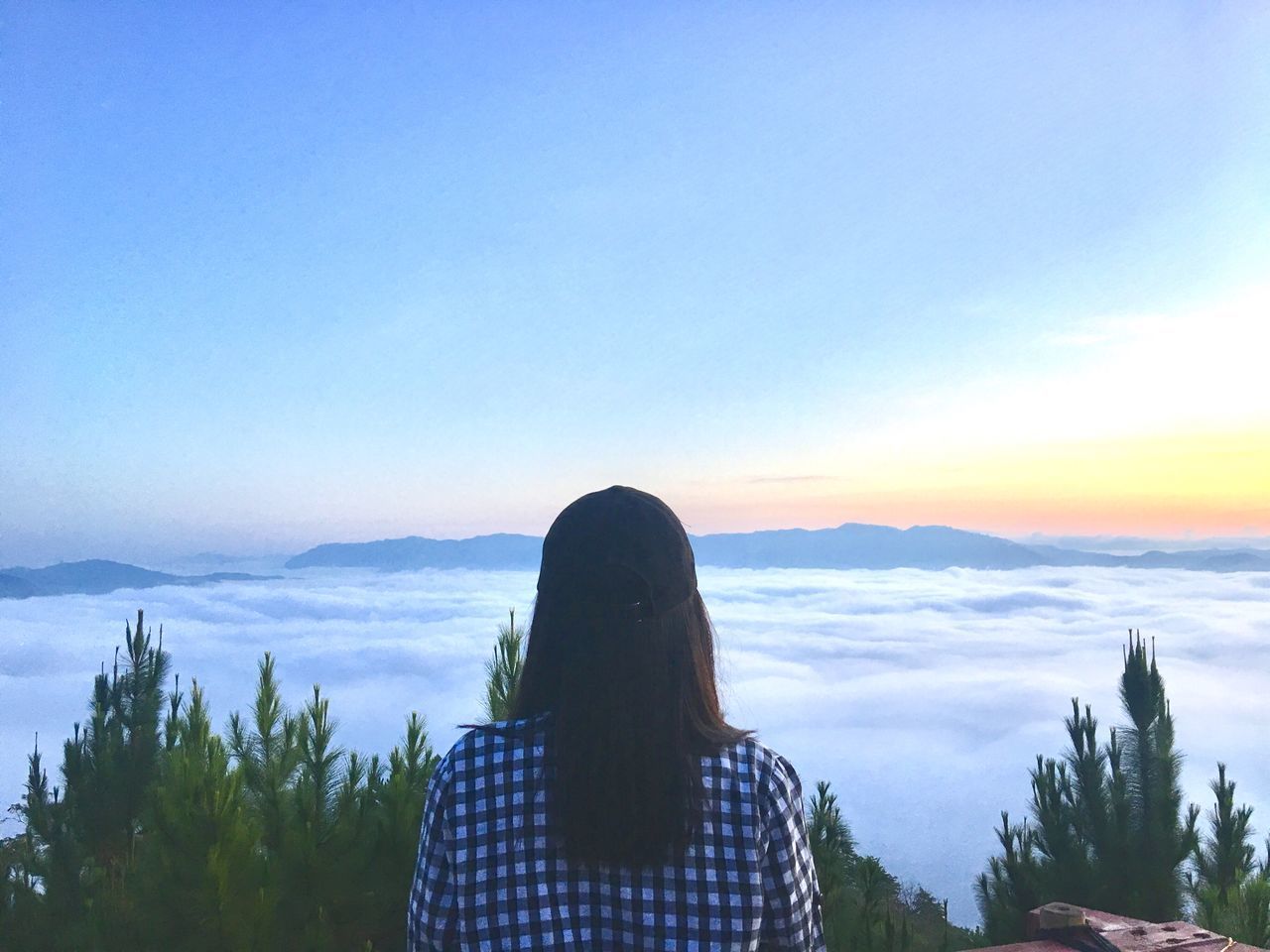 REAR VIEW OF WOMAN LOOKING AT MOUNTAINS AGAINST SKY DURING SUNSET