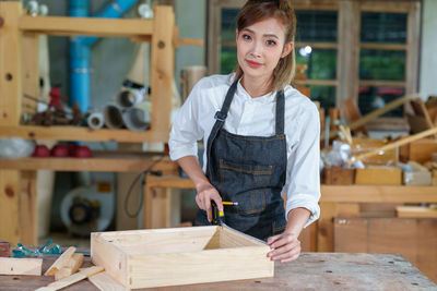 Portrait of beautiful asian woman carpenter dealing with handicraft