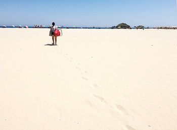 Rear view of woman walking on beach