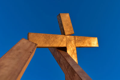 Low angle view of cross against clear blue sky