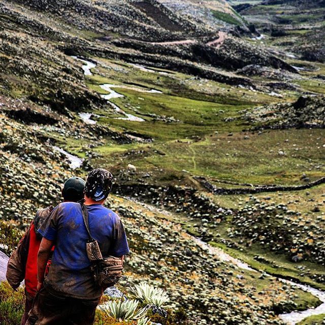 lifestyles, rear view, leisure activity, men, landscape, casual clothing, full length, nature, hiking, tranquility, rock - object, standing, field, backpack, tranquil scene, mountain, beauty in nature, day