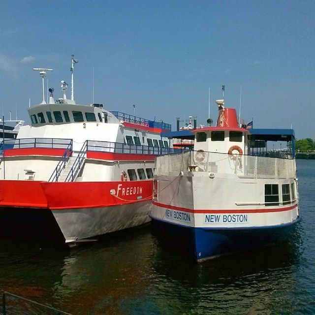 nautical vessel, transportation, water, mode of transport, boat, waterfront, moored, clear sky, built structure, architecture, sea, building exterior, river, day, travel, outdoors, sky, no people, harbor, blue