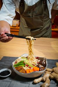Midsection of person preparing food in restaurant