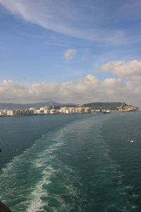 Scenic view of sea by buildings against sky