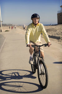 Man riding bicycle on road against clear sky