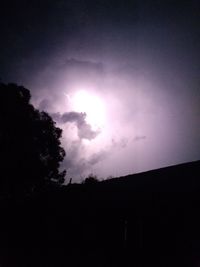 Low angle view of silhouette building against sky at night