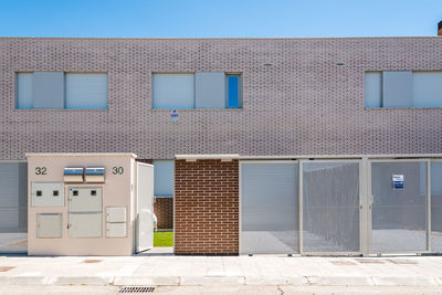 Exterior view of modern semi-detached townhouses with brick facade. sunny day