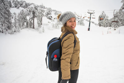 Portrait of woman standing on snow covered land