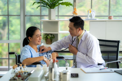 Side view of female friends working in office