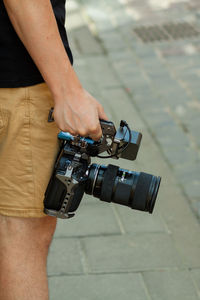 Midsection of man holding camera