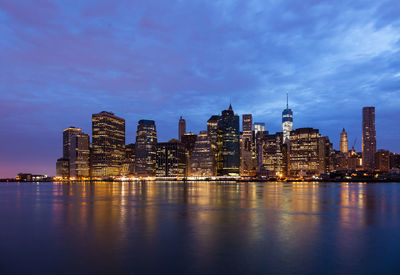 Illuminated buildings against sky at dusk