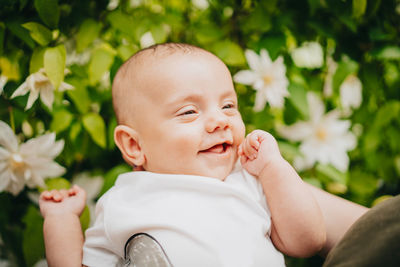 Close-up of cute baby boy against plants