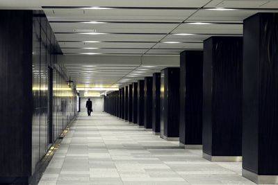 Rear view of man walking in corridor of building