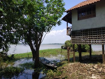 House by lake against sky