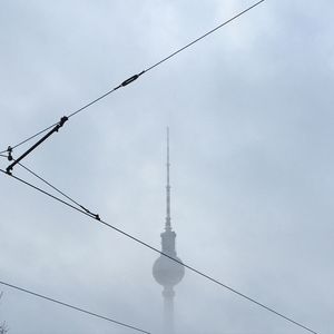 Low angle view of power lines against sky