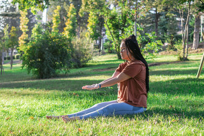 Woman is doing yoga asana outside in a park. concept of balancing and healthy lifestyle.