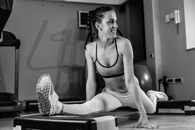 Woman stretching legs in gym