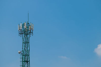 Low angle view of communications tower against blue sky