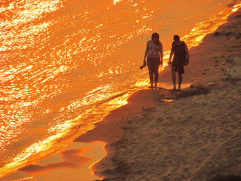 Tourists on beach at sunset