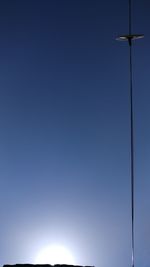 Low angle view of windmill against clear blue sky