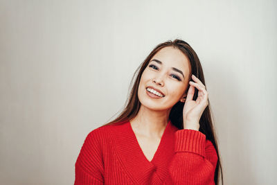 Portrait of a smiling young woman against white background