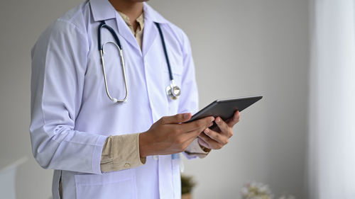 Midsection of man holding mobile phone