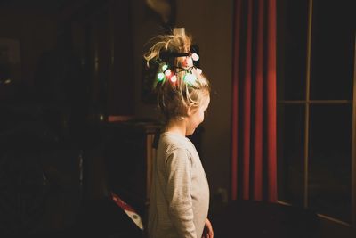 Side view of girl standing at home