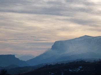 Scenic view of snowcapped mountains against sky during sunset