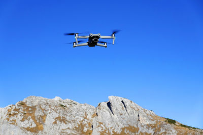 Low angle view of camera against clear blue sky