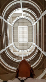 Rear view of woman sitting on staircase