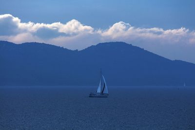 Boat sailing in lake with mountain in background