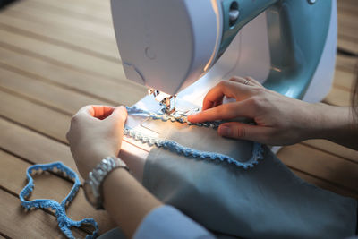 Charming girl with long black hair sews 