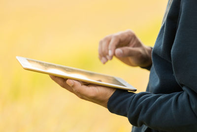 Midsection of man holding paper