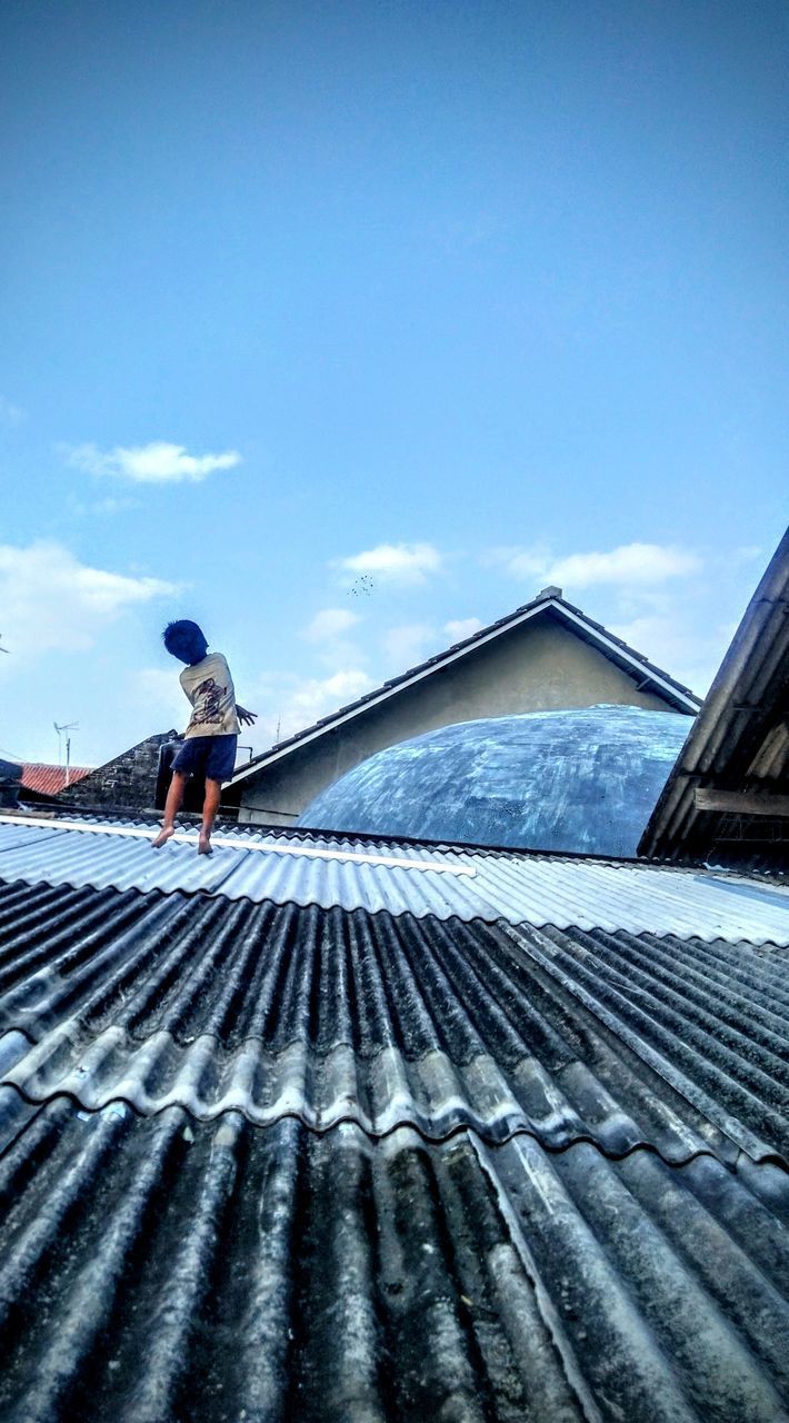 MAN WORKING ON ROOF OF BUILDING