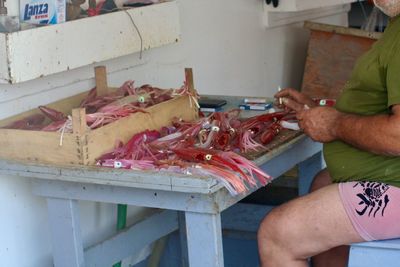Midsection of man working at fish