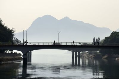 Bridge over river against sky during sunset